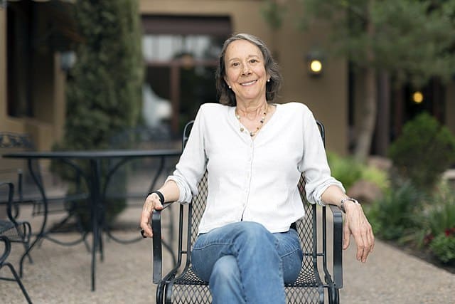 Photo of Esther Dyson seated in a chair. One of Our Executive Search Clients